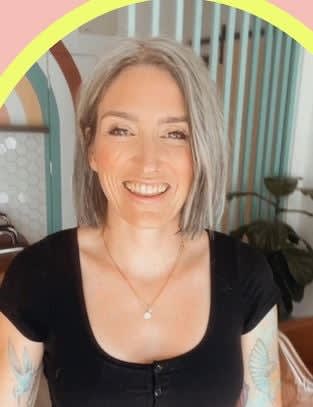 A woman smiling, wearing a black top.