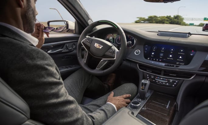 A driver sitting in the passenger seat of a 2019 Cadillac CT6 while Super Cruise pilots the vehicle.