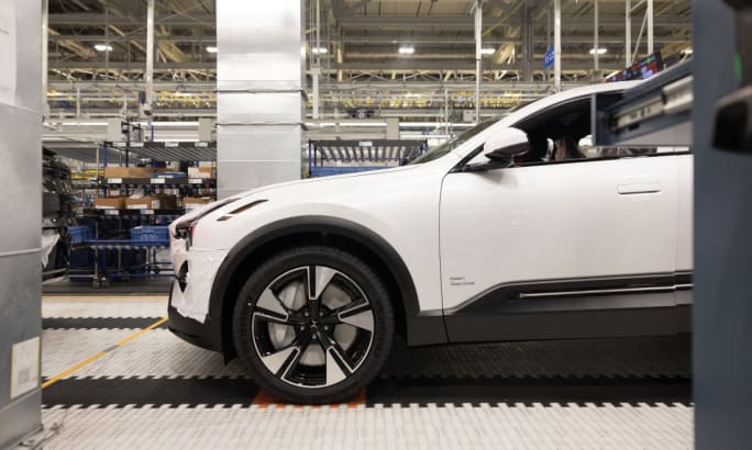 A side view of a white Polestar 3 in a manufacturing warehouse.