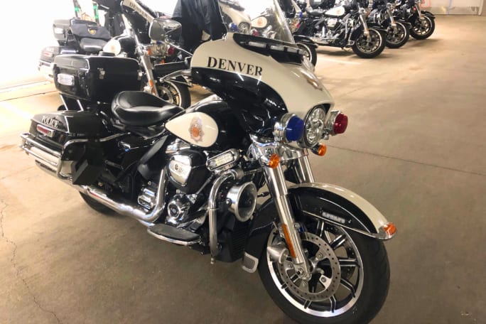 A Denver Police Department motorcycle is shown with a row of more of them behind it.