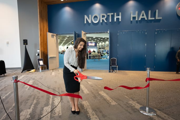 Government Fleet Executive Editor Nichole Osinski cuts the ribbon for the exhibit hall with a large pair of scissors at the 2024 Government Fleet Expo & Conference.