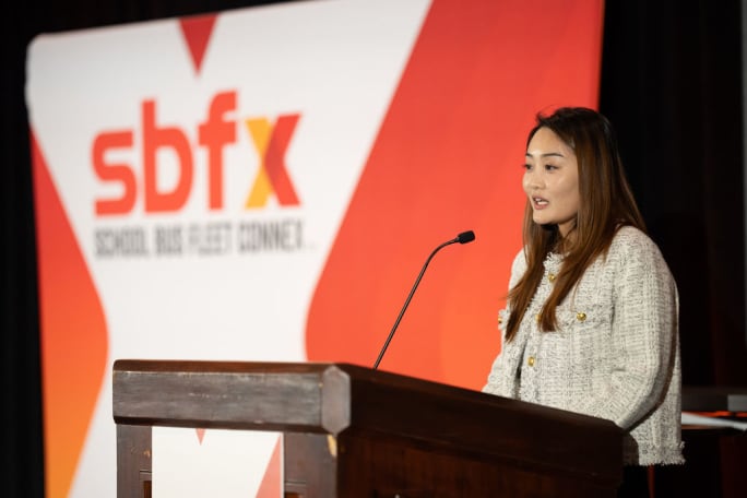 a woman stands in front of a podium