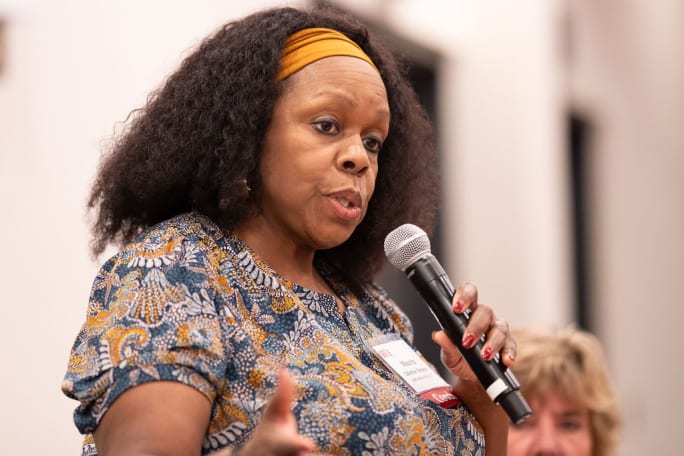 a woman speaks into a microphone