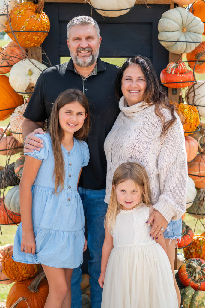 Jamie McKay stands next to her husband and two daughters.