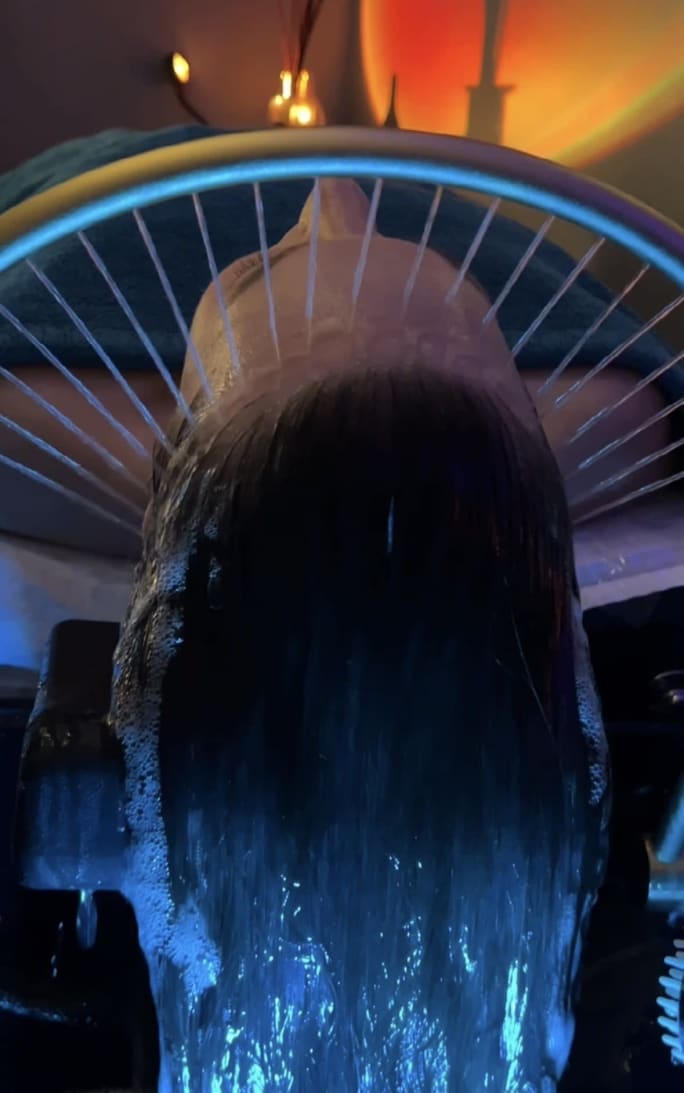 A client under an arch of streaming water at Essense Salon and Sanctuary.