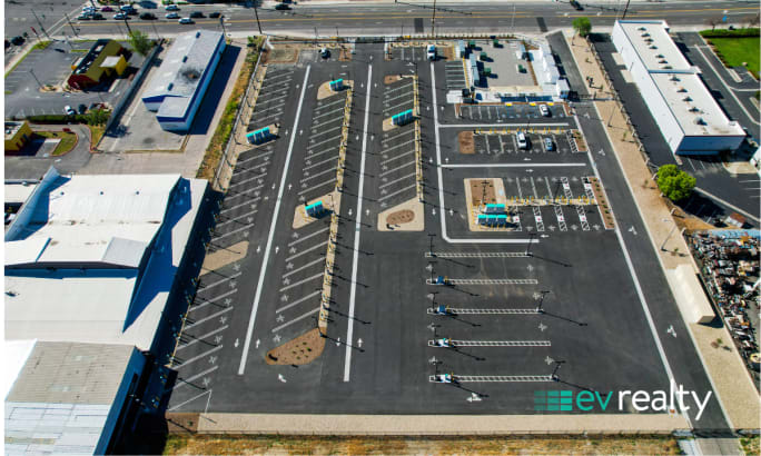 Overhead view of EV truck charging facility with organized lanes, charging stations, and parking areas for commercial fleet operations.