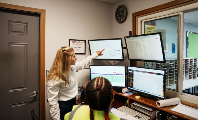 two women look at computer screens showing transportation data