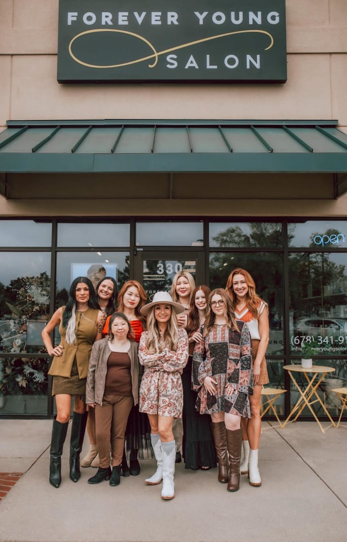 An owner and her team stand proudly in front of Forever Young Salon.
