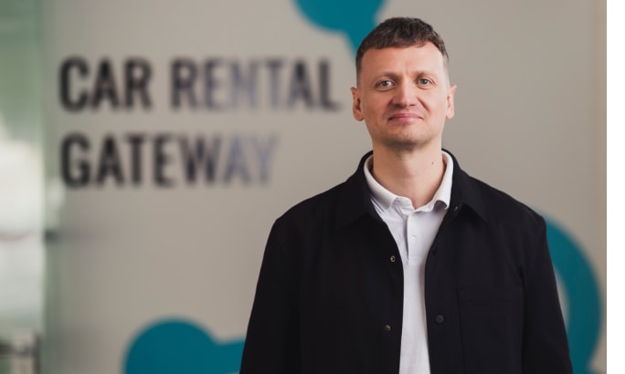 Hannes Poldvee in front of the Car Rental Gateway wall logo.