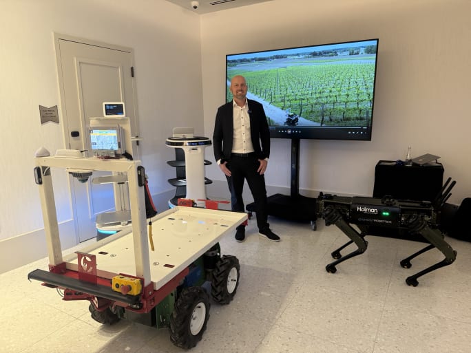 Man standing amidst various robots.