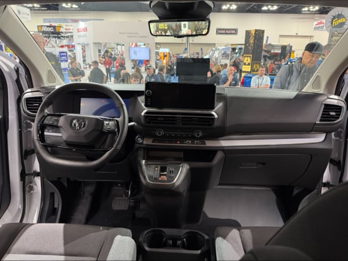 Interior dashboard and steering wheel of the 2027 Ram ProMaster City showing the digital instrument cluster, center touchscreen, and commercial van cockpit at Work Truck Week 2026.
