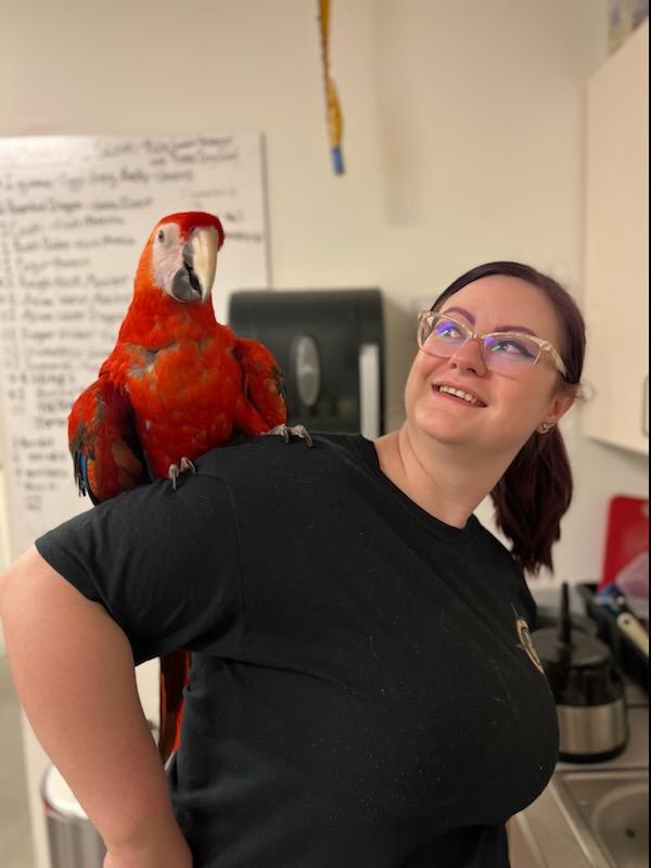 Mikhaila Baldwin poses with a red bird on her shoulder.