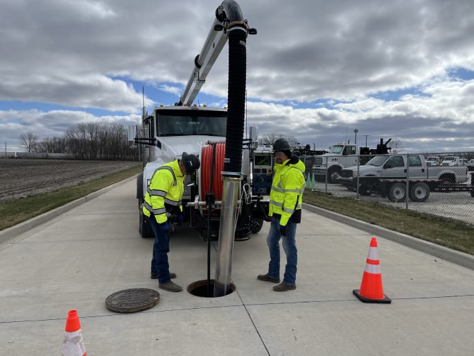 The vacuum is seen at work in a manhole.