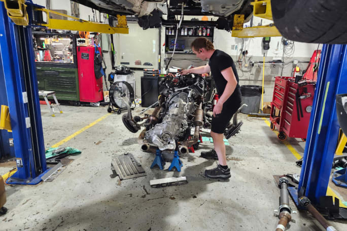 A dealership employee works with a Dodge Durango Pursuit engine.