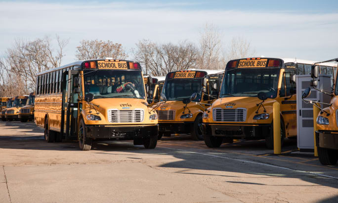 Multiple Thomas Built electric buses in a bus yard,