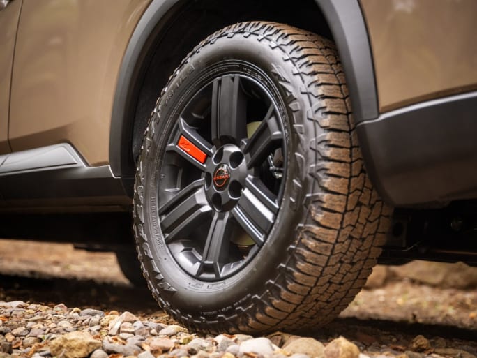 Close up of a a tan car's dirty tire.