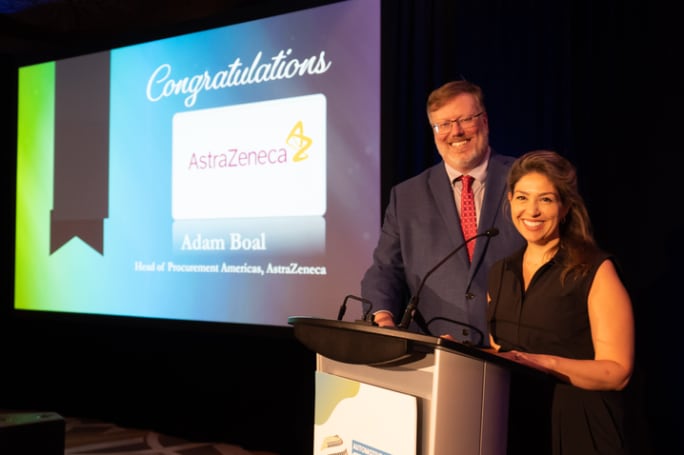 A man and a woman post on stage behind a podium.
