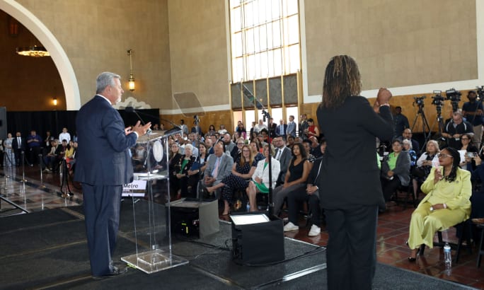 Board Chair Fernando Dutra addressing a crowd on state with an ASL interpreter.