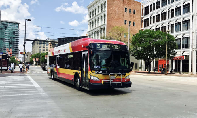 A red Maryland Transit Administration bus on the street.