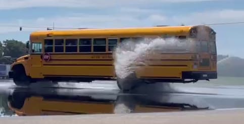 a school bus skids through water
