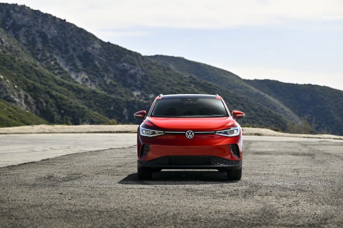 A red ID.4 SUV sits in front of mountains.