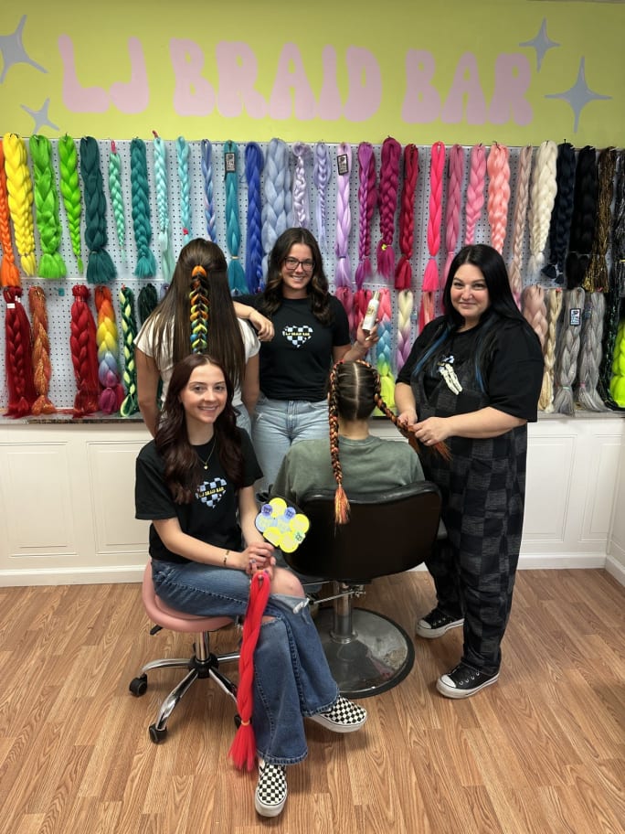 Salon team posing with clients in a salon.