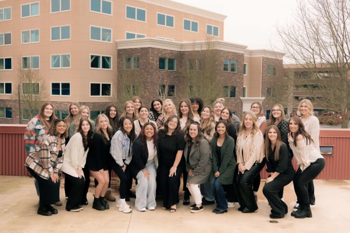 Posing in front of commercial buildings, the team from Lonestar Salon & Spa.
