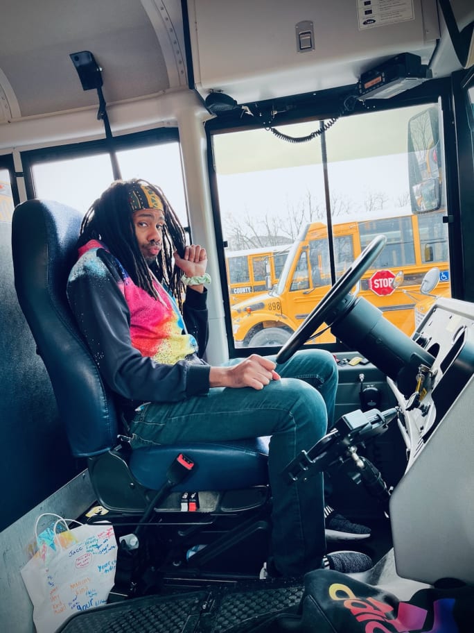 a man sits behind the wheel of a school bus