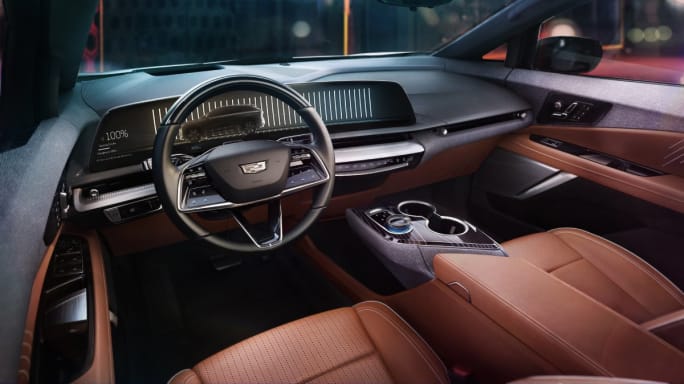The high tech interior of a car with smooth brown seats and a black dashboard.