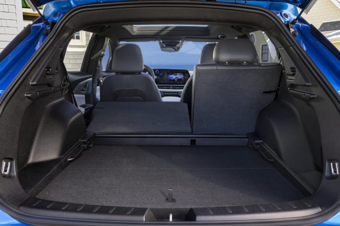 Interior cabin of a blue Chevrolet Equinox EV SUV through open trunk door.