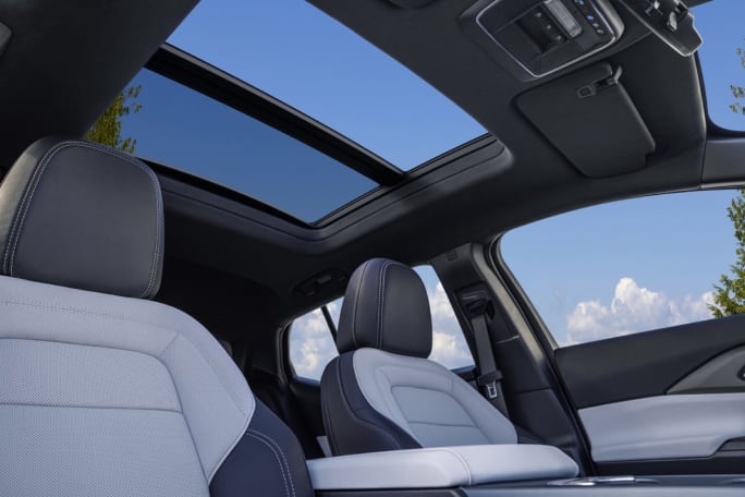 Interior of a car with black and white seats and a sun roof.