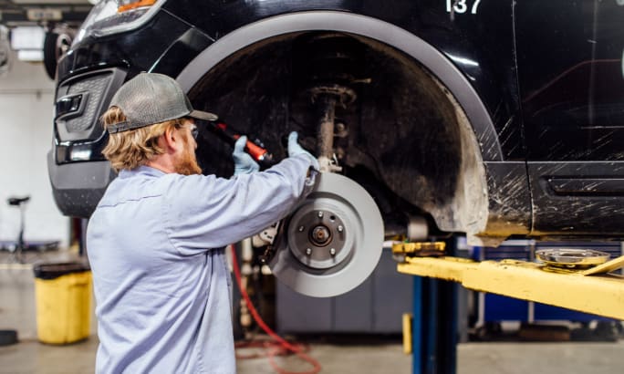A technician working on a vehicle tire.