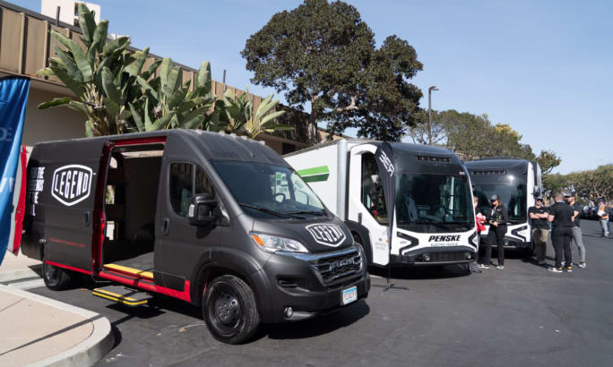 Electric trucks on display in parking lot. 