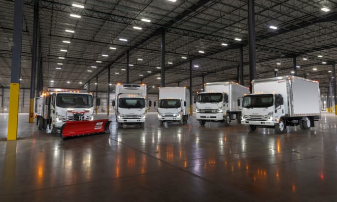 Lineup of Isuzu trucks in a warehouse.