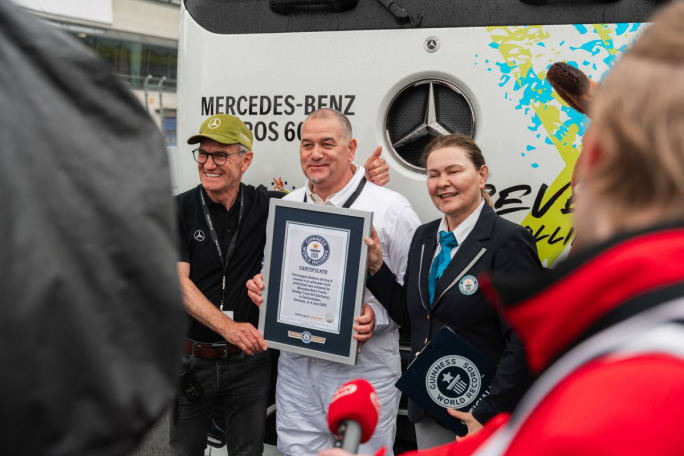  Marco Hellgrewe (center) and Werner Kempfle, Development Engineer and Co-Project Manager of the eActros 600, receive the award from Seyda Subasi-Gemici, Adjudicator, Guinness World Records Limited.