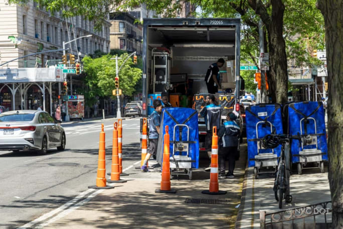 Box truck unloading curbside in a microhub into smaller delivery vehicles