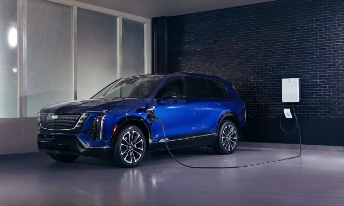 A bold blue 2026 Cadillac Vistiq charging in a gray room with interior windows.