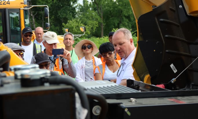A crowd looks under the hood of Durham School Services Ann Arbor school buses.