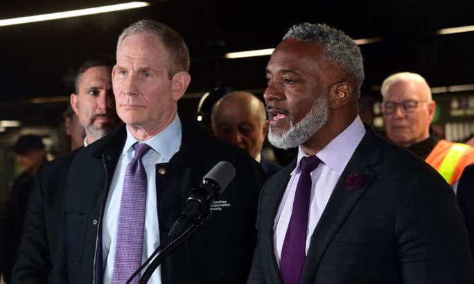 A group of people stand at a podium during a press conference.