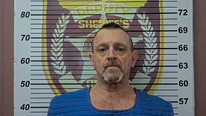 Mugshot of middle-aged person against sheriff's height measurement background