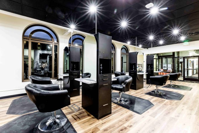 Black chairs face black stations in Origins Salon.