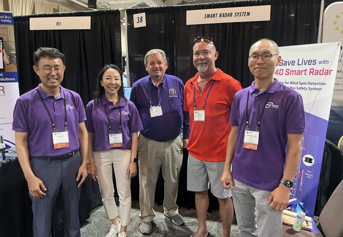 a group of people stand together at a trade show