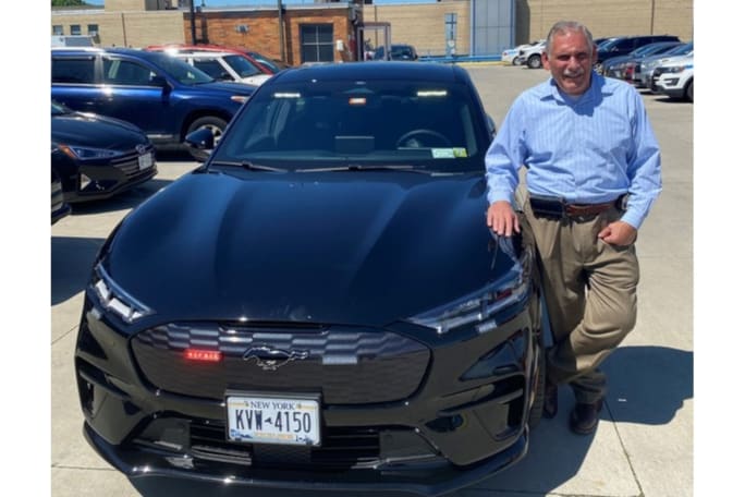 NYPD Deputy Commissioner Robert Martinez stands with the agency's first Ford Mustang Mach-E in August 2022. This vehicle is used for administrative duties. (Photo: Courtesy of Robert Martinez)[|CREDIT|]