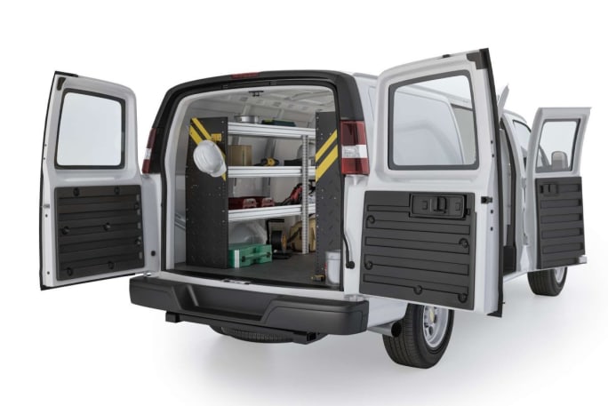 A white work van on a white background upfitted with vocational-specific storage in the cargo area.