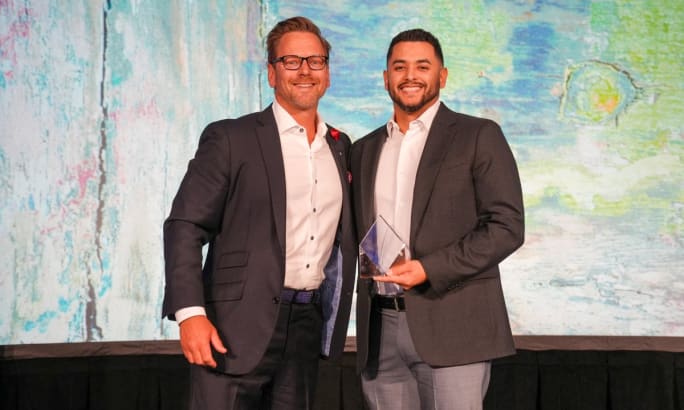 Ernie Garcia and Brad Burgess pose on stage during the AFLA conference.
