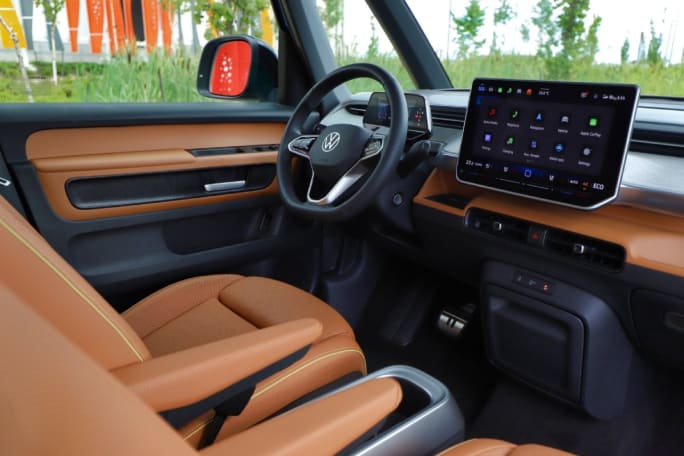 The front driver seat and dashboard of a Volkswagen ID. Buzz in the color Copper.