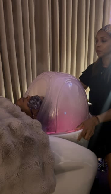 A hairdresser sitting behind a headspa shampoo bowl