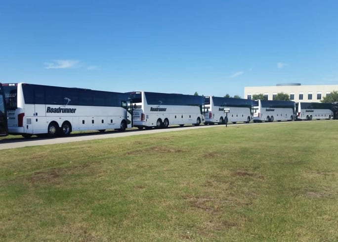 Line of Roadrunner motorcoach buses parked outdoors