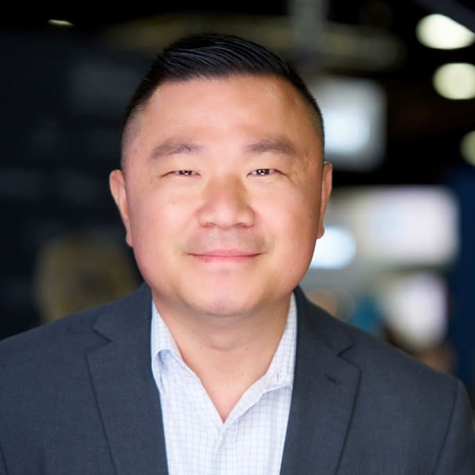 A business portrait of a man in a blue suit.