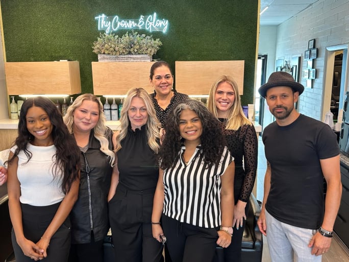 The team from Thy Crown and Glory Salon & Headspa pose under their logo in neon.